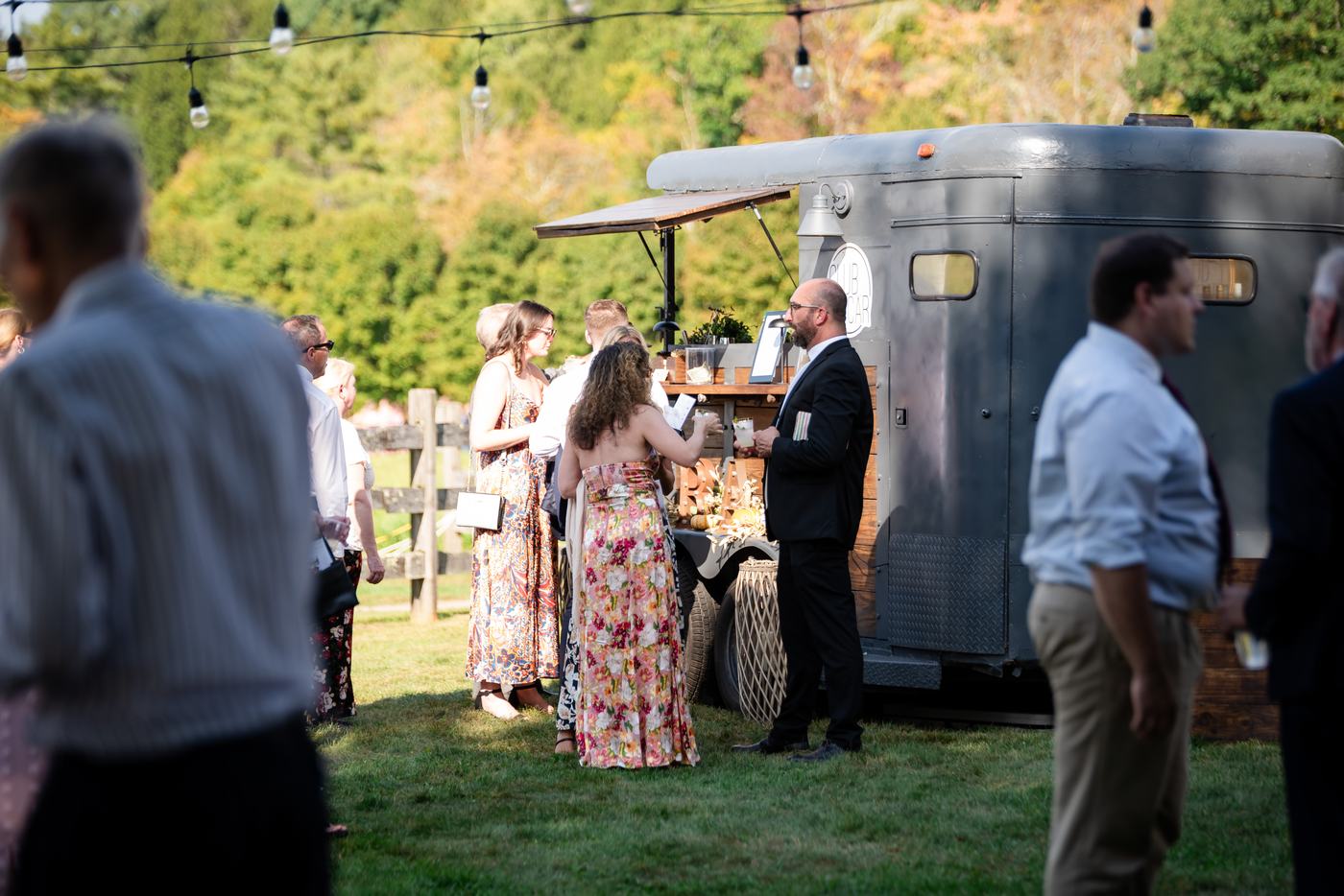 Guests gathered around the Club Car bar at an outdoor event