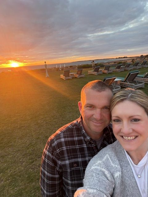 Charlie and Megan Foster smiling together at sunset