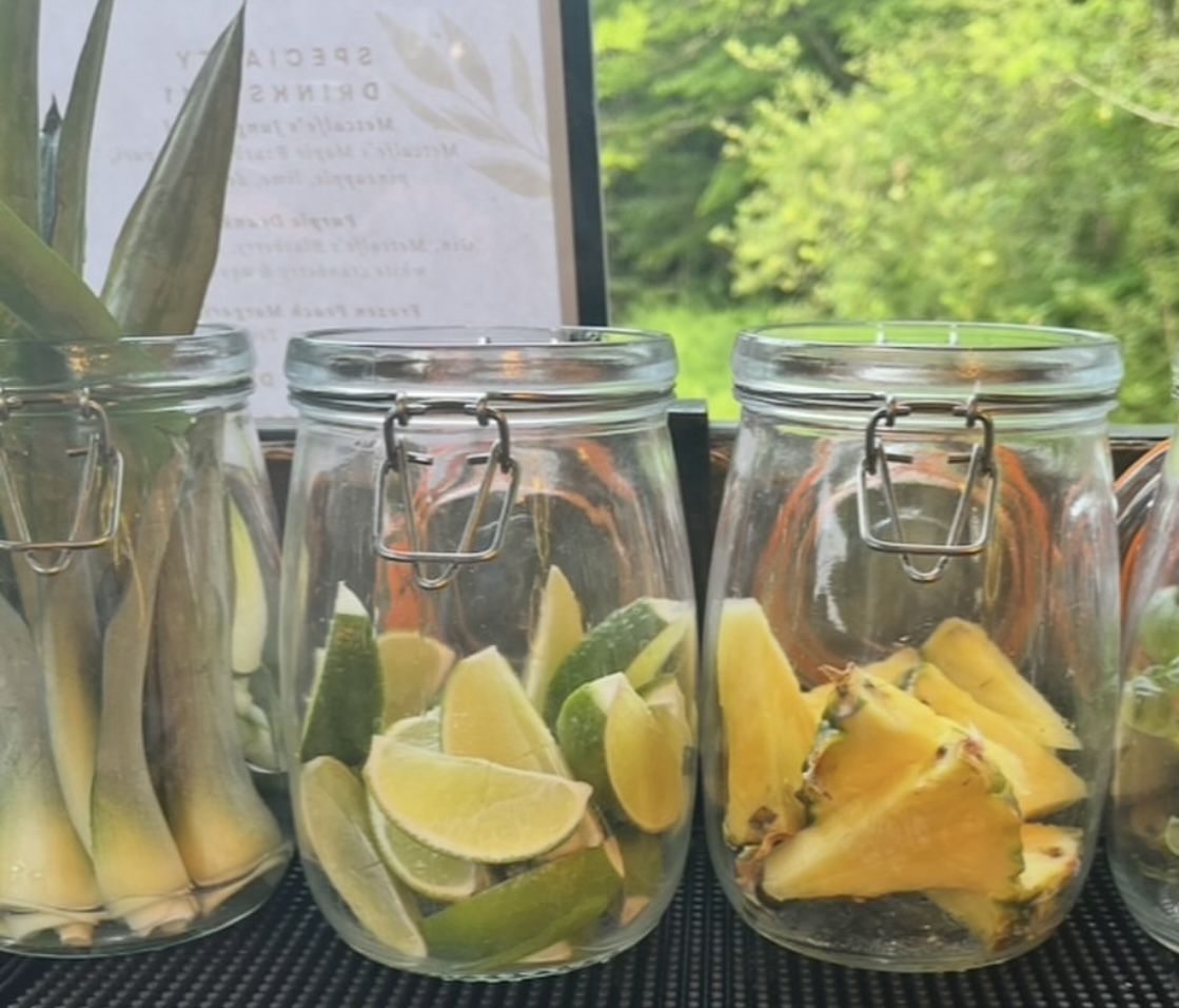 Fresh garnish jars of lime, pineapple, and cucumber for cocktail service