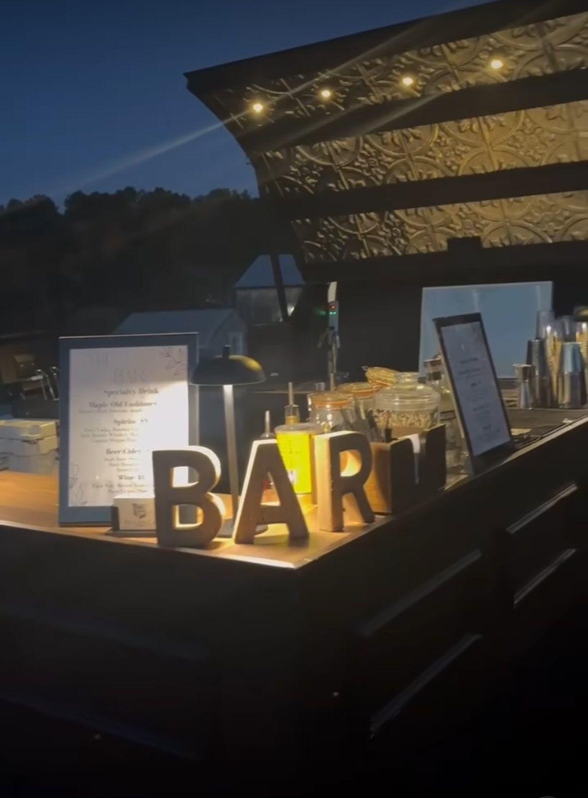 The Side Car bar lit up with string lights at dusk
