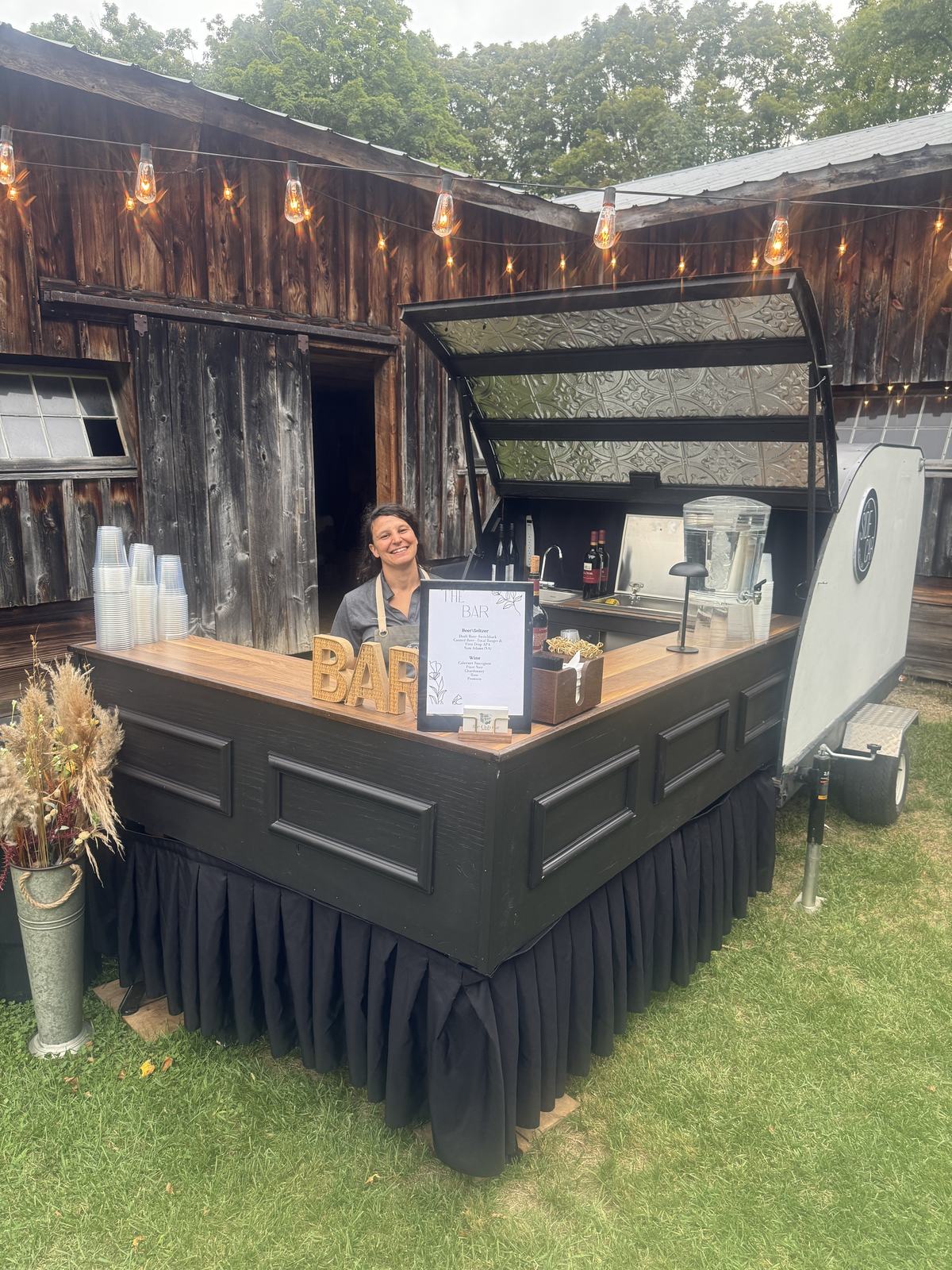 Bartender serving guests from the Side Car trailer bar