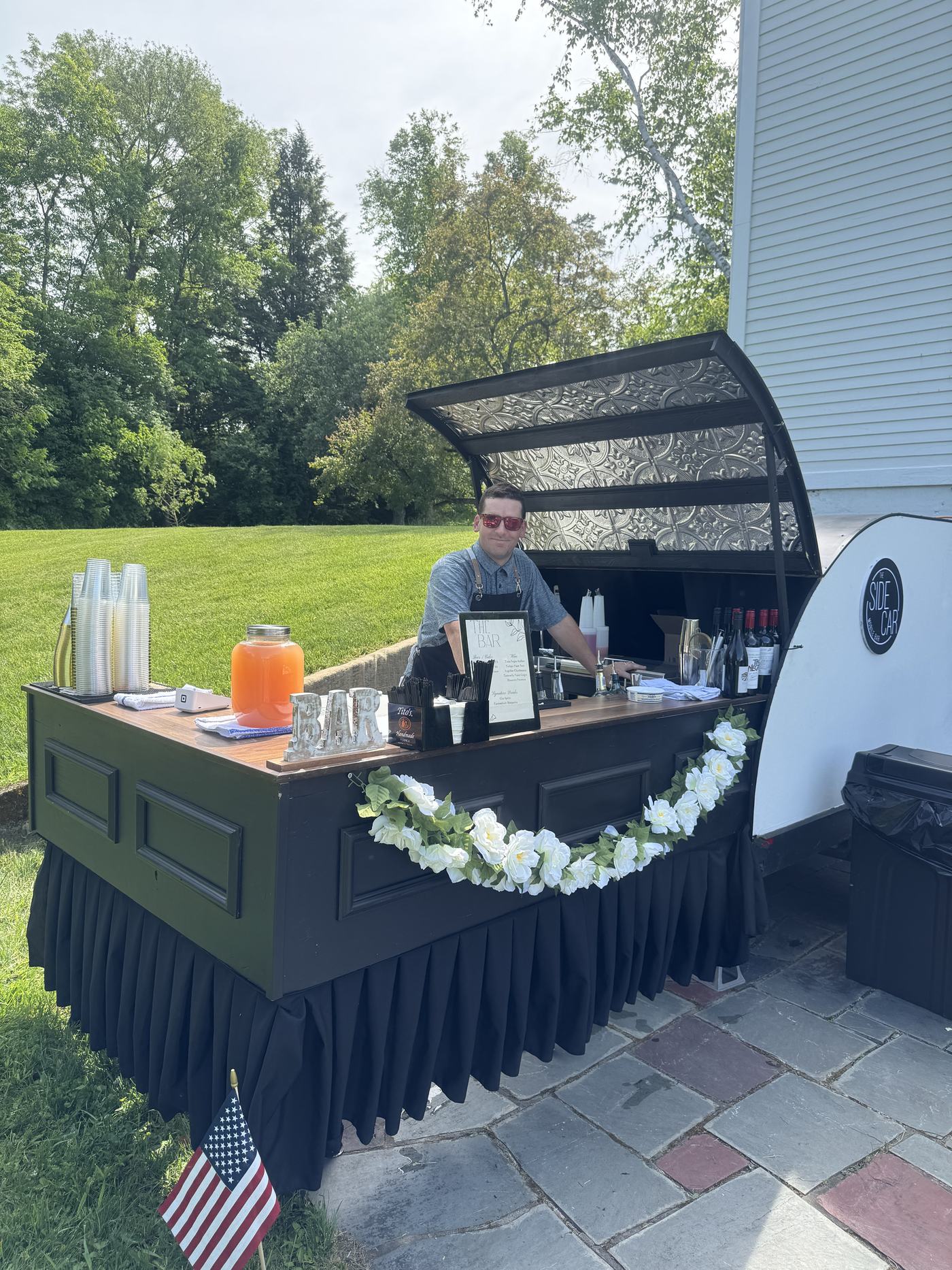 The Side Car mobile bar on a sunny day with a bartender at the counter
